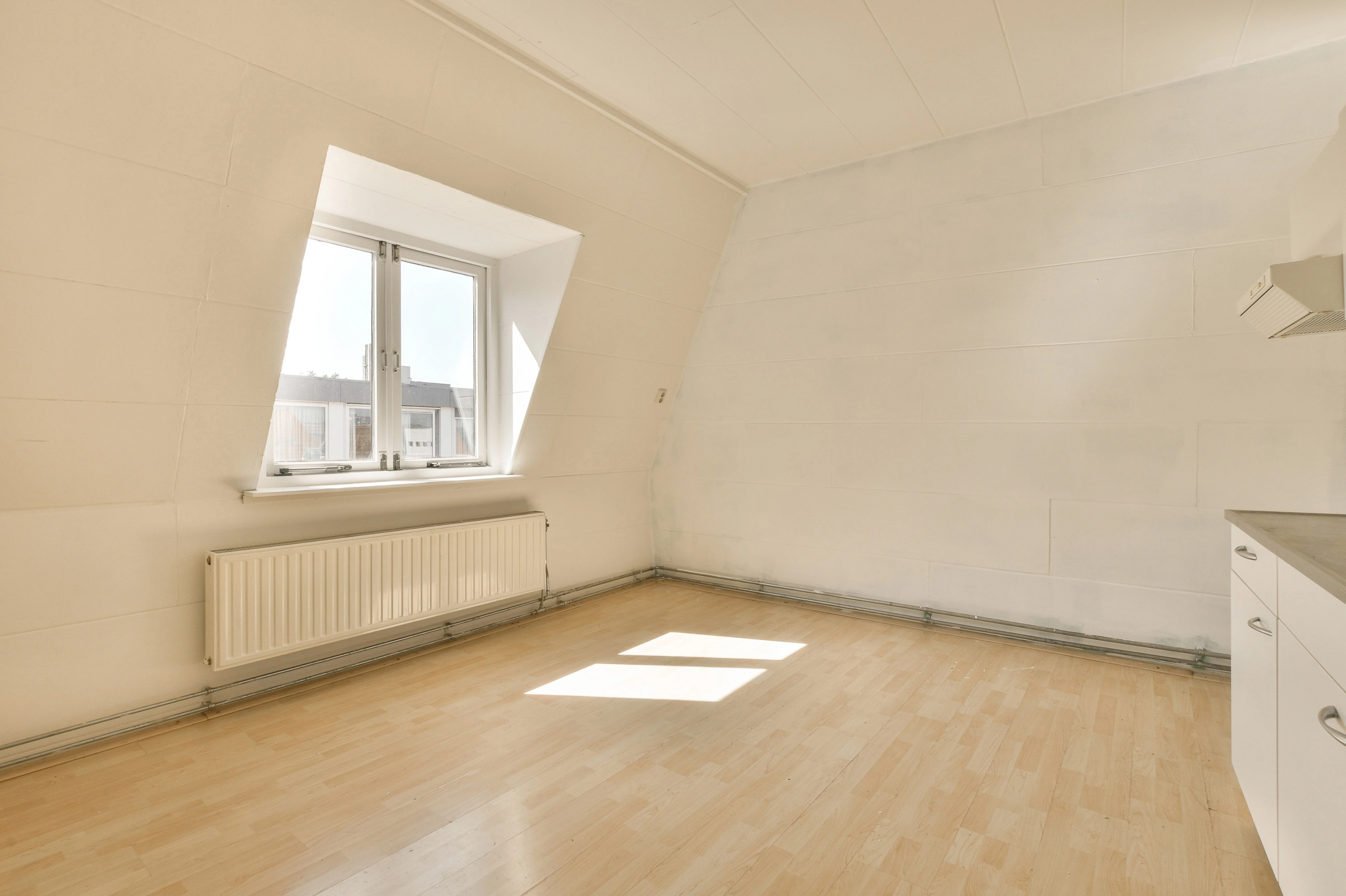 Bedroom before, with plain walls and dated furniture